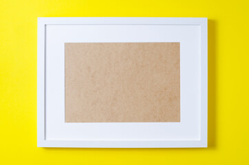 Frame for text on a yellow background. Cardboard, paper, top view.