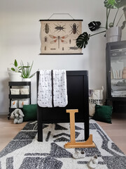 Contemporary black and white baby nursery with a nature theme with plants and jungle decoration.