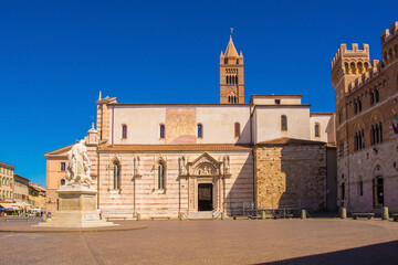 Fototapeta premium The Romanesque Cattedrale di San Lorenzo, Saint Lawrence Cathedral, in Piazza Dante, Grosseto, Tuscany. On the right is Palazzo della Provincia, on the left Canapone Monument, Monumento a Leopoldo II 