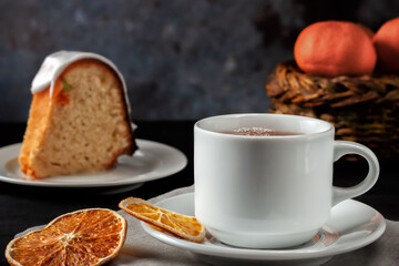 Cup of tea with oranges and a piece of homemade muffin