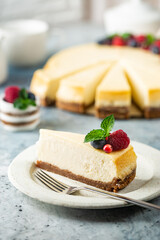 Classic New York cheesecake with fresh berries on light blue concrete background