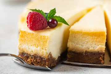 Classic New York cheesecake with fresh berries on white concrete background