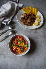 Boiled vegetables and chicken wings with use of selective focus.