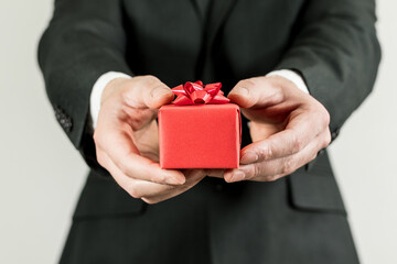 Young man, romantic guy offering small gift box. Gift and special day concept.