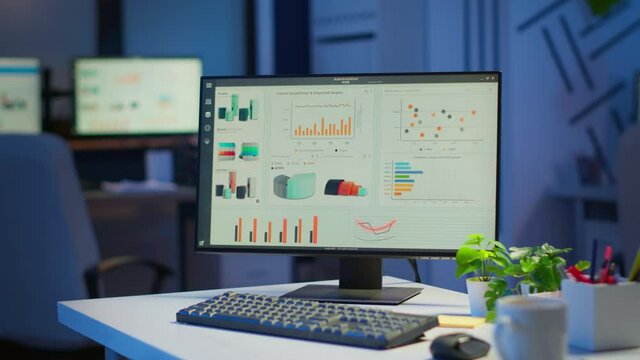 Financial company with nobody in it, place of work startup, workplace indoors concept. Interior of empty start up business office with modern design during night with graphics running on the desktop.