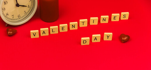 Concept of valentine's day background on red with decoration, red hearts and alarm clock for lovers, theme banner
