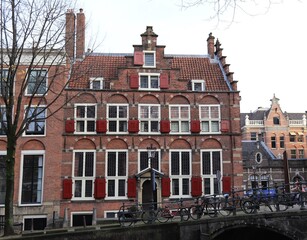 Fototapeta premium Traditional Amsterdam Canal Building with Red Shutters in Amsterdam