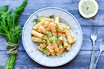  Italian home made  macaroni pasta with smoked salmon , creamy sauce and fresh dill on wooden background