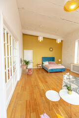 Scandinavian style apartment interior. bright yellow warm colors. wooden flooring. sunlight in large windows.