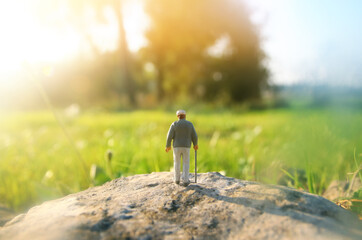 Obraz premium Surreal image of mysterious man walking alone in field during sunset