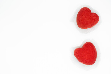 A bright red heart-shaped cakes on a white background. Copy space