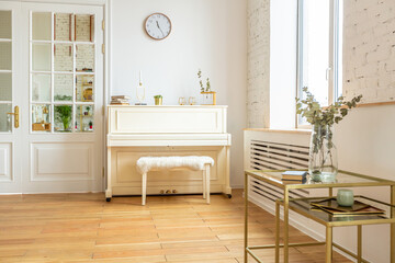 the interior of the study in the style of a loft. Brick wall. wooden flooring. large bright room with a seating area. sofa and piano