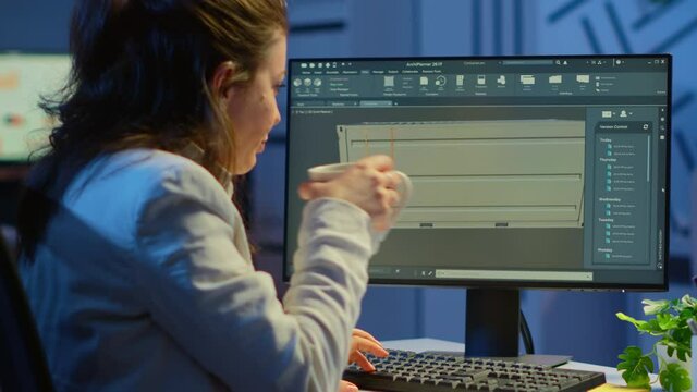 Freelancer architect working in 3D software to elaborate container design sitting at desk in business office at midnight. Focused engineer creating and studying prototype, analysing scale model.