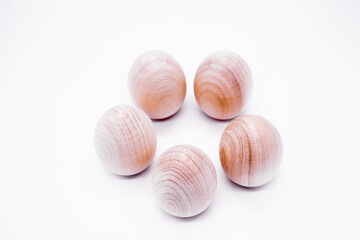 Five hand-made unpainted wooden eggs on a white background