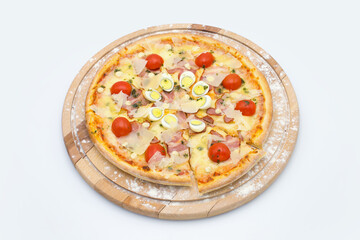 Whole meat Pizza in Caesar salad style on wooden board served with culinary flour, isolated on white background. Dish with cherry tomatoes tomatoes, chicken, bacon, parmesan cheese, quail eggs
