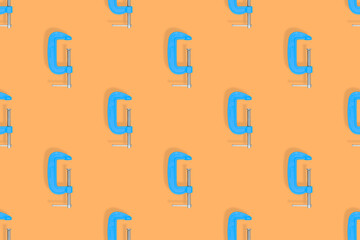 Clamp seamless pattern. Pattern of a metal clamp on an orange background.