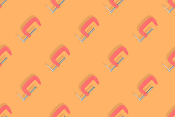 Clamp seamless pattern. Pattern of a metal clamp on an orange background.