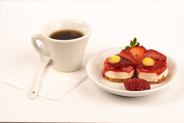 white cup expresso of coffee with strawberries and purple flowers on a table ready for breakfast...