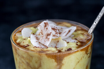 Green avocado smoothie with black coffee and coconut chips during the morning breakfast