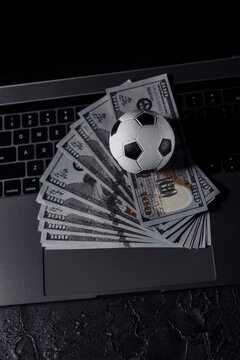 Bets, sports betting, bookmaker. Soccer ball on a laptop's keyboard. Vertical image.