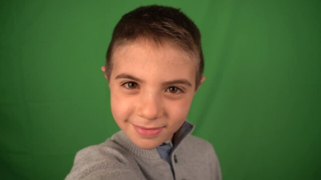 Child taking selfie isolatad over green screen background on smartphone