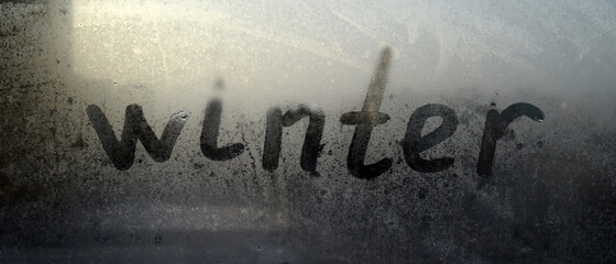 On the fogged glass is the inscription "winter". Twilight.