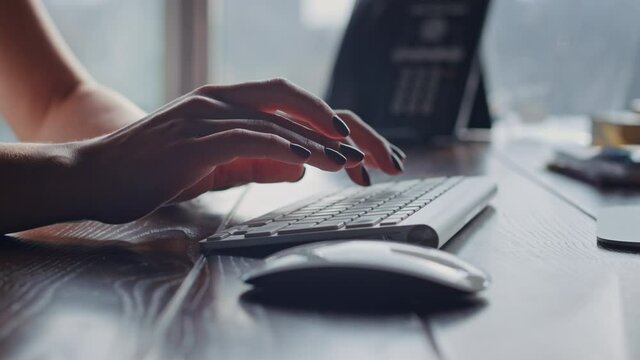 Beautiful hands of female bisiness worker typing text on desktop computer keyboard in a modern office. Co Wroking online job space