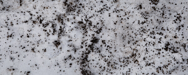 Badly stained texture on the snowy road 
