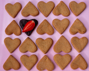 Pattern of homemade heart shaped cookies for Valentine's day on pink background