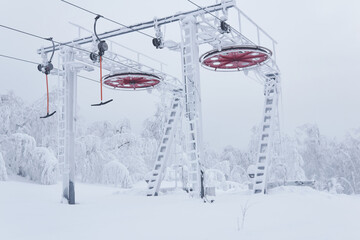 upper station of the ski lift on a snow-covered hilltop among frosty trees