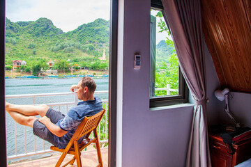 a man on vacation on a hotel balcony looking at the resort