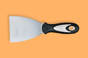 Putty trowel with rubberized handle on an orange background.