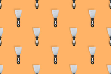 Putty trowel seamless pattern. Spatulas for on an orange background.