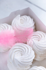 Four white marshmallows in a box on a white background. Delicate handmade apple dessert.