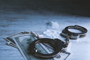 Drugs and handcuffs composition. Selective focus. Crime concept. Illegal money.