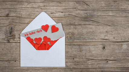 Valentinstag Liebe Grußkarte Konzept Banner. Umschlag, Karte mit Text, Ich liebe dich! und vielen roten Herzen auf braunem rustikalem Holztisch Textur Hintergrund Draufsicht
