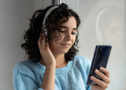 Young woman listening to music with mobile phone