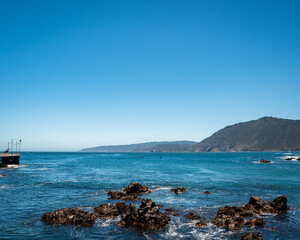 Fototapeta na wymiar Vista general de Caleta Quintay con montñas y el océano pacífico en el fondo 