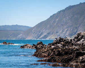 Fototapeta na wymiar Vista general de Caleta Quintay con montñas y el océano pacífico en el fondo 