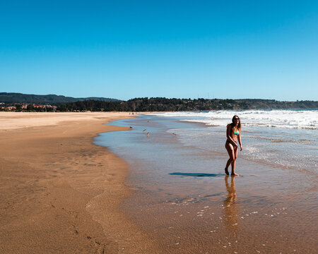 Joven mujer disfrutando de un día soleado en la playa de Quintay en la Región de Valparaíso, Chile