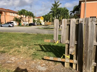 Old rustic, broken wooden fence gate planks for security in private Miami Dade County suburban...