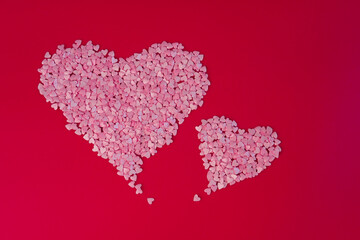 Two big hearts made of small hearts on red background. Love, wedding and happy valentine minimal concept. Copy space