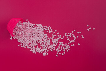 Small pink hearts scattered on red background. Love, wedding and happy valentine minimal concept