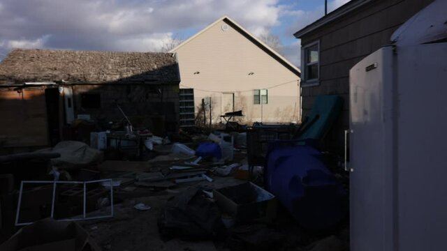 Clutter and garbage surrounding house walking through the backyard.