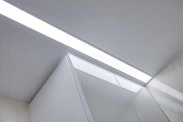 Fototapeta premium suspended ceiling with halogen spots lamps and drywall construction in empty room in apartment or house. Stretch ceiling white and complex shape.