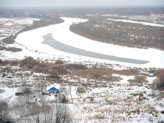 view of the house near the winter frozen river