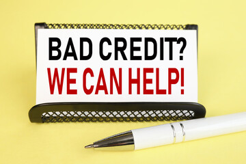 bad credit we can help, text on white paper on yellow background