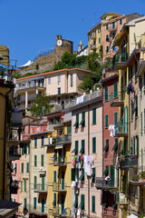 Fototapeta na wymiar Typical street with its colorful facades of Village of Riomaggiore, a commune in the province of La Spezia, situated in a small valley in the Liguria region of Italy