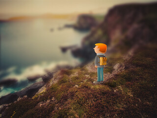 Hiker with rucksack standing on isolated coastal cliff edge looking out at horizon at sunset hybrid photo and illustration.