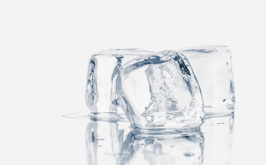 Melting natural crystal clear ice cubes on white reflective surface.